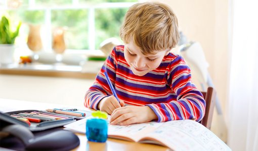 Romrodinka via Gettyimages Kind übt schreiben