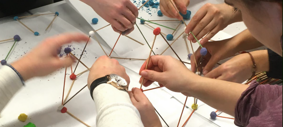 gibt eine mathematische Aufgabe mit Holzstäben und Kugeln in Rot, Weiß und Blau aus