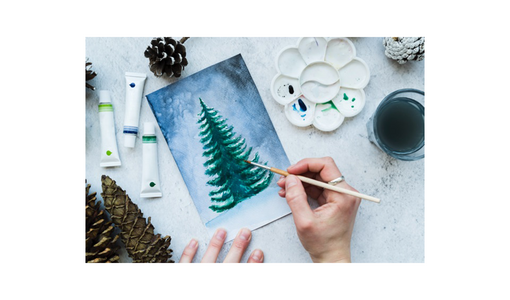 Draufsicht auf eine Frau, die von Hand einen Weihnachtsbaum auf eine Leinwand malt